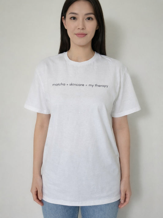 Person wearing a white t-shirt with text on a plain background