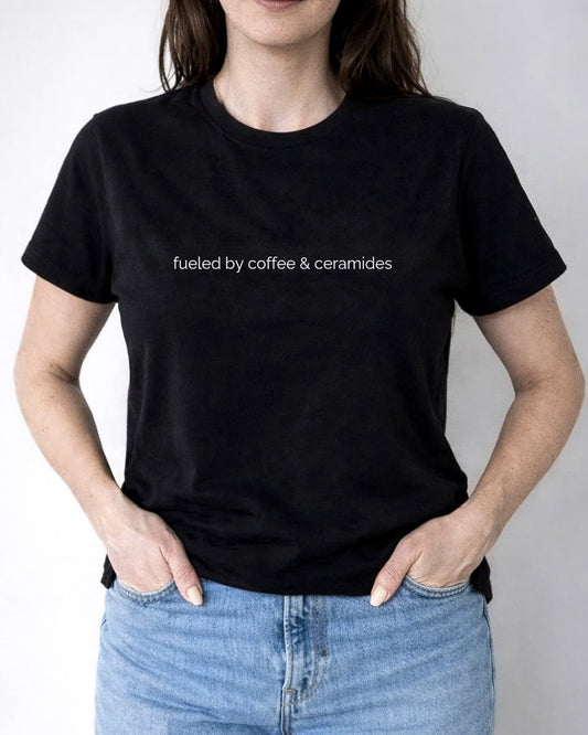 Person wearing a black t-shirt with 'fueled by coffee & ceramics' text, standing against a plain background.