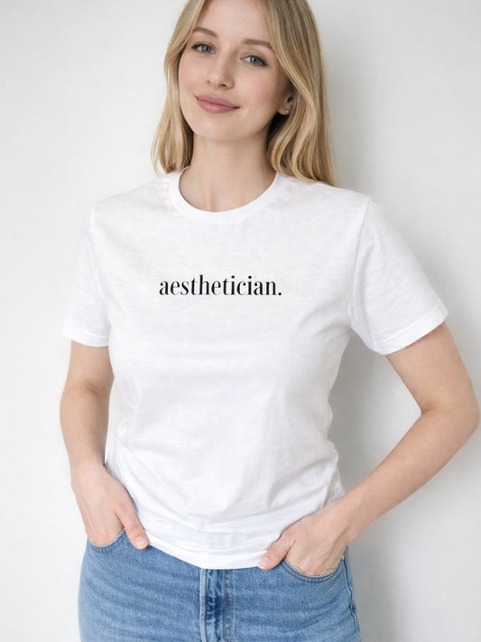Woman wearing a white t-shirt with 'aesthetician' text against a plain background